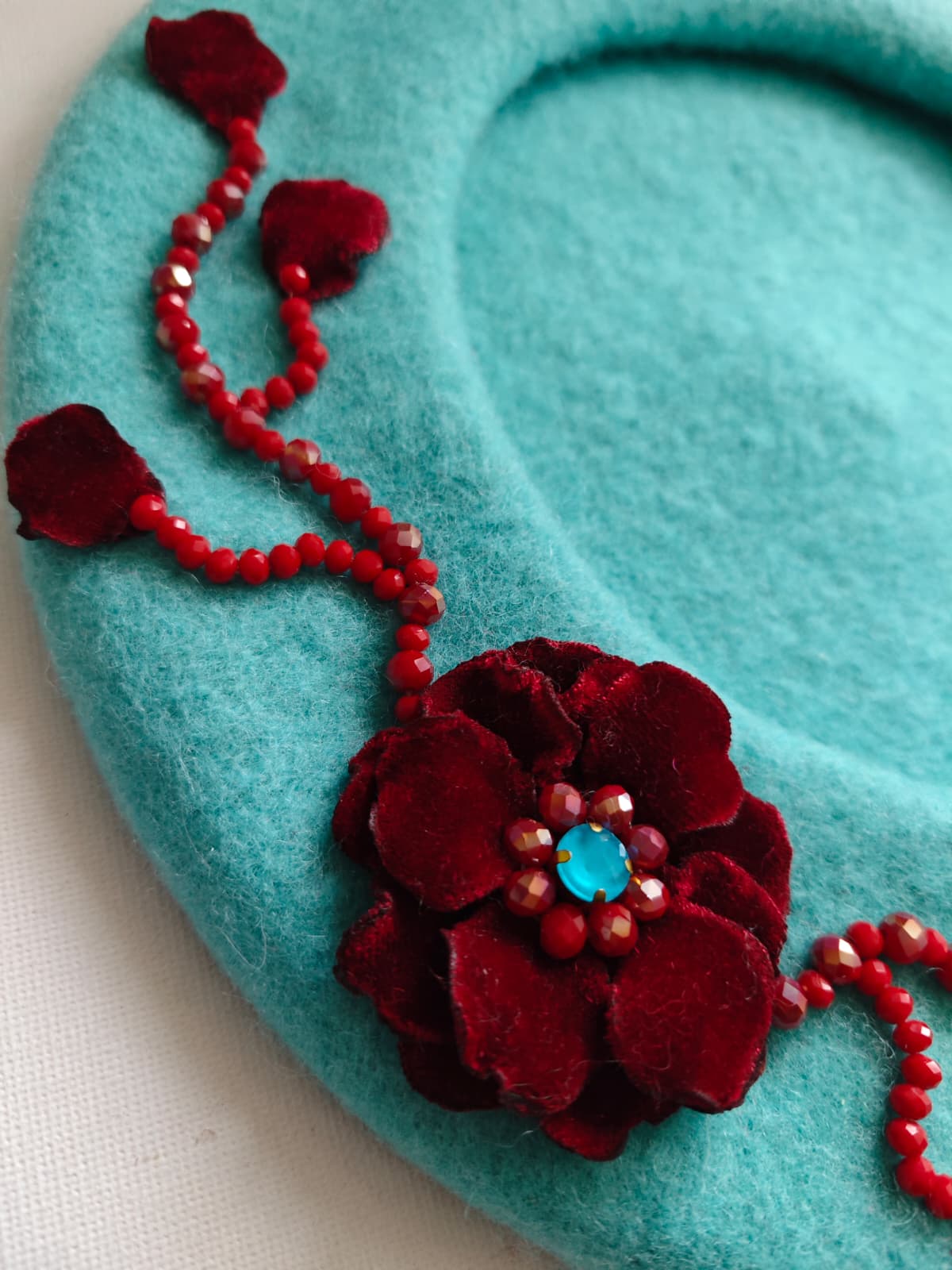 Beretă handmade turcoaz din lână 100% cu decor bordo EZO